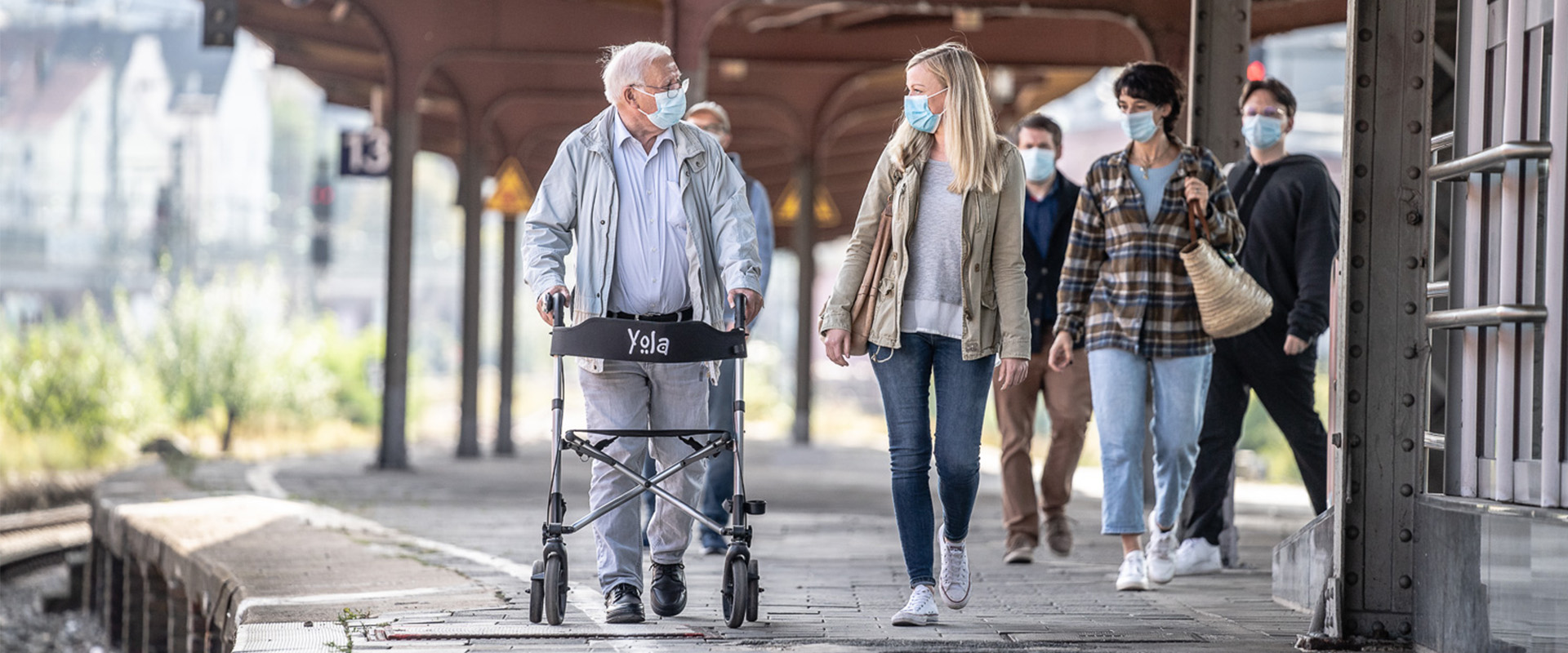 Ein Mann mit Rollator läuft am Bahnsteig entlang