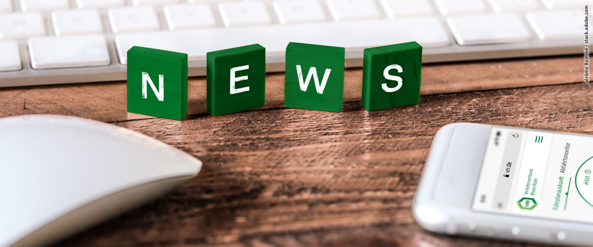 Jérôme Rommé Grüne Holzplättchen mit weißem Schriftzug "NEWS" auf einer Holzfläche