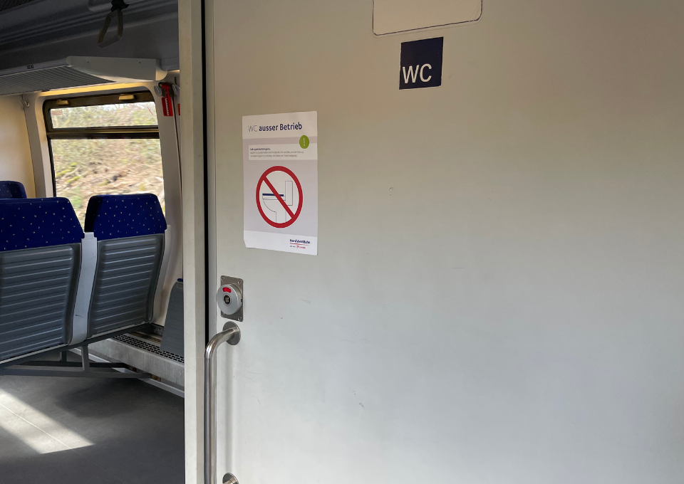 Eine Zugtoilette mit einem Defekt-Hinweis an der Tür