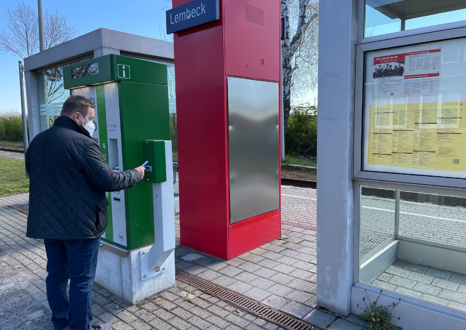 Ein Mann bedient am Bahnhof den Fahrkartenentwerter