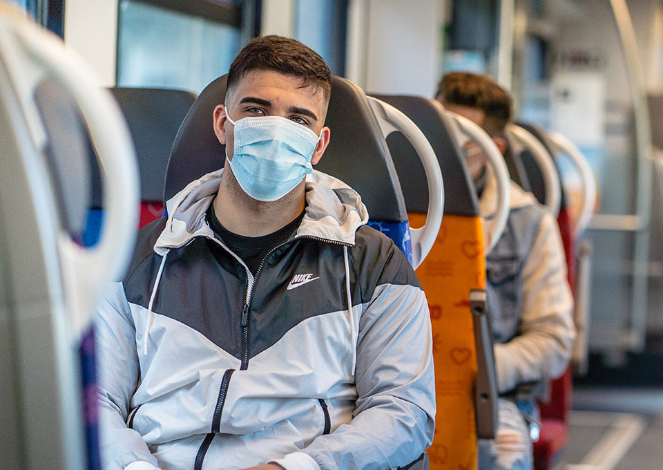 Fahrgast mit Maske im Zug