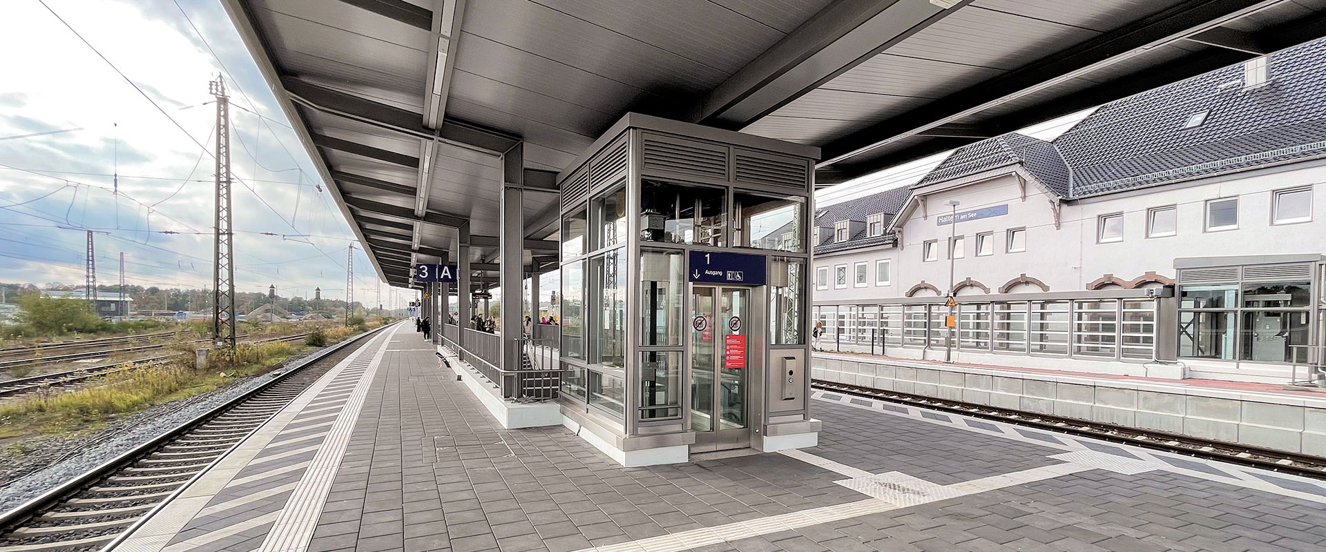 Überdachter Bahnsteig mit Aufzug, Treppe und taktilem Leitsystem