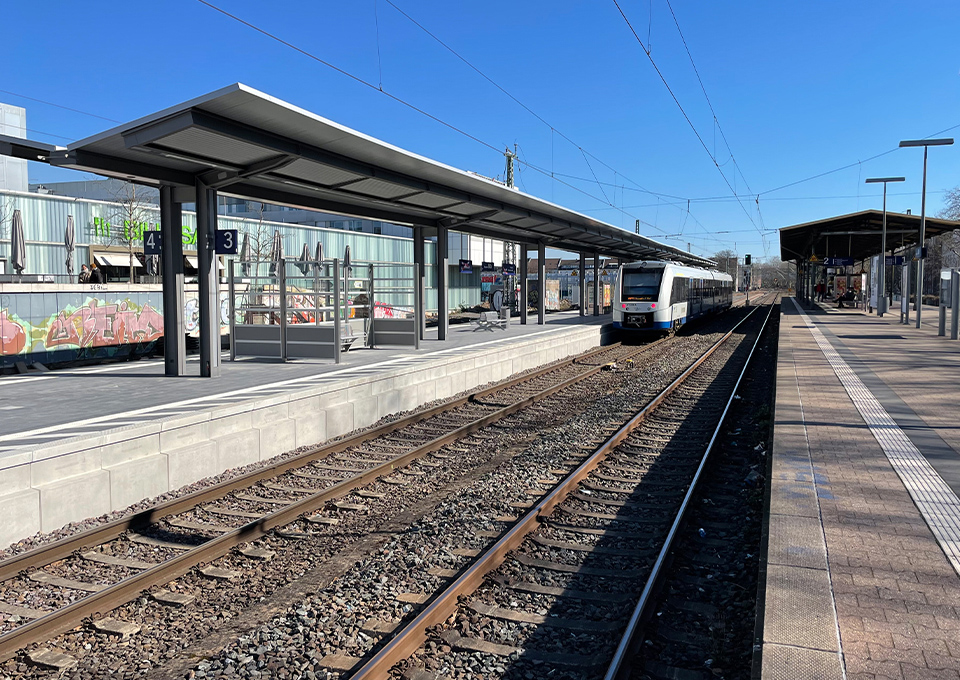Der neue Regionalbahnsteig mit Wartebereich und haltendem Zug an Gleis 3