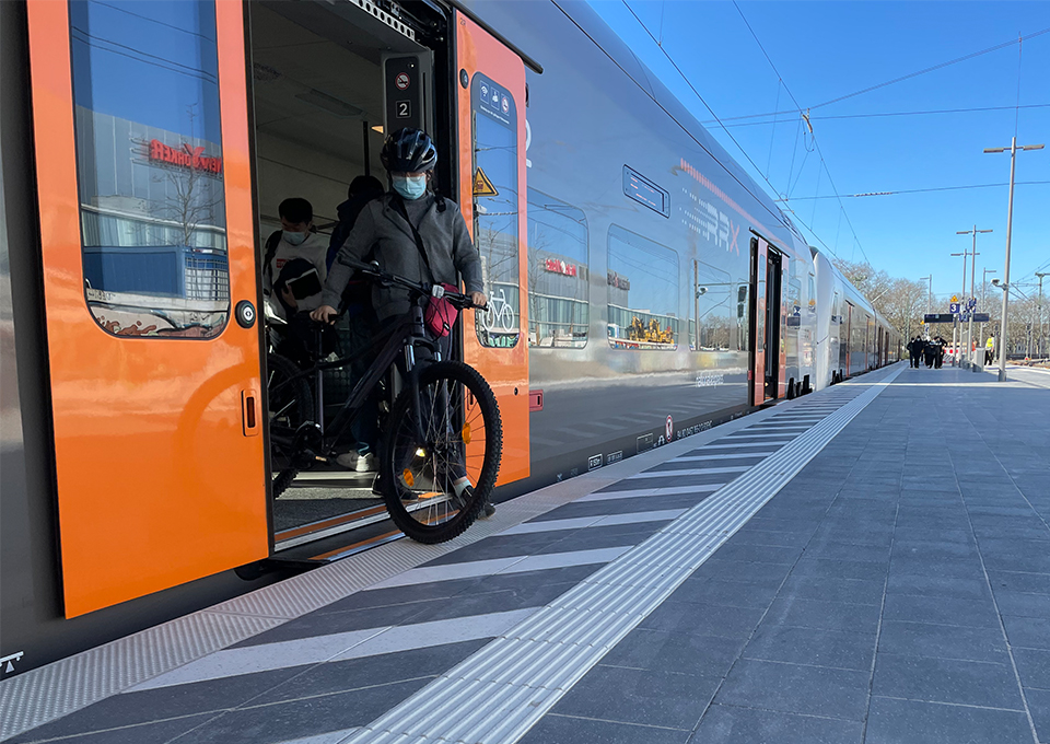 Person steigt niveaugleich aus einem RRX-Zug am neuen Regionalbahnsteig aus