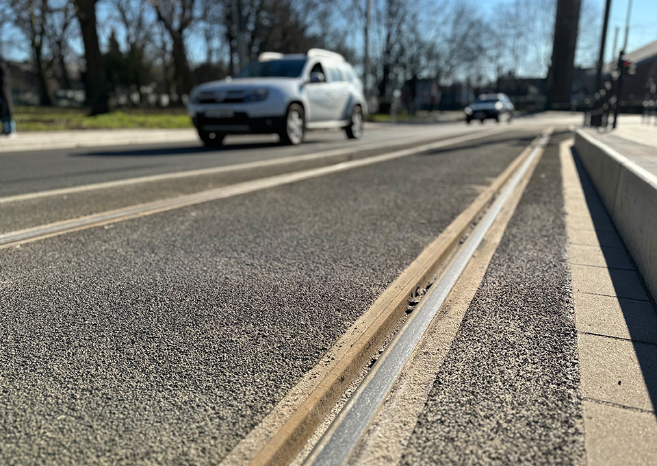 Neubau Haltestelle Brückelstraße: Detailaufnahme der neuen Gleise, im Hintergrund sind verschwommen Autos zu sehen