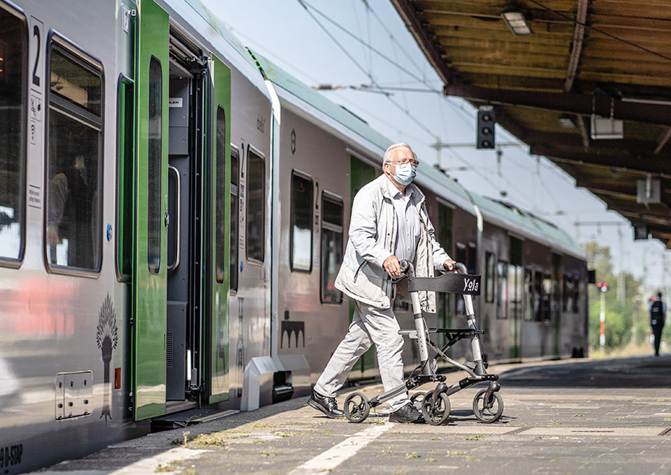 Eine Person mit Rollator verlässt niveaugleich einen S-Bahn-Zug