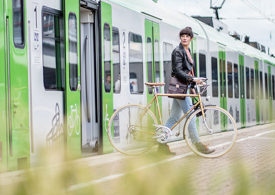 Eine Frau steigt mit Fahrrad aus einer S-Bahn
