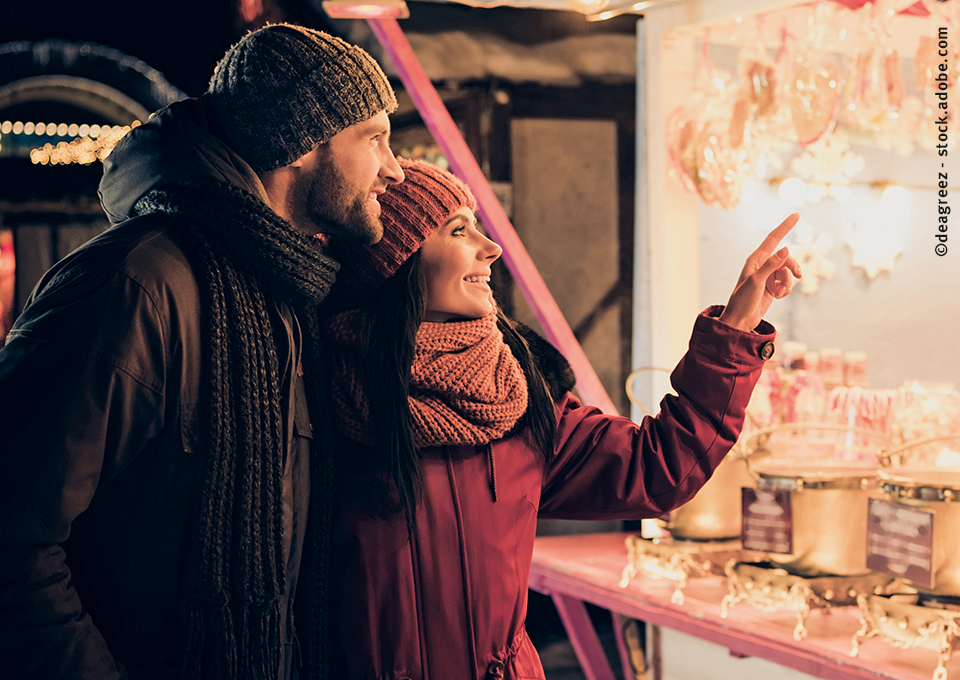 A happy couple stroll through the Christmas market