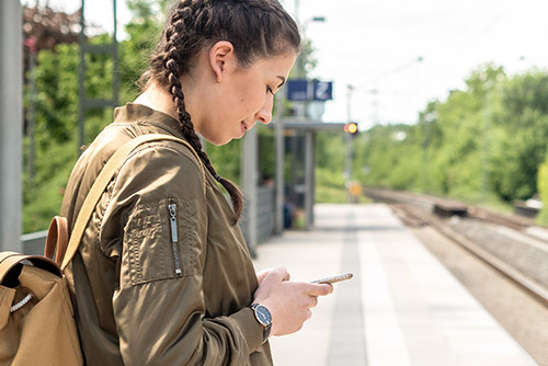 A young girl looks at her phone